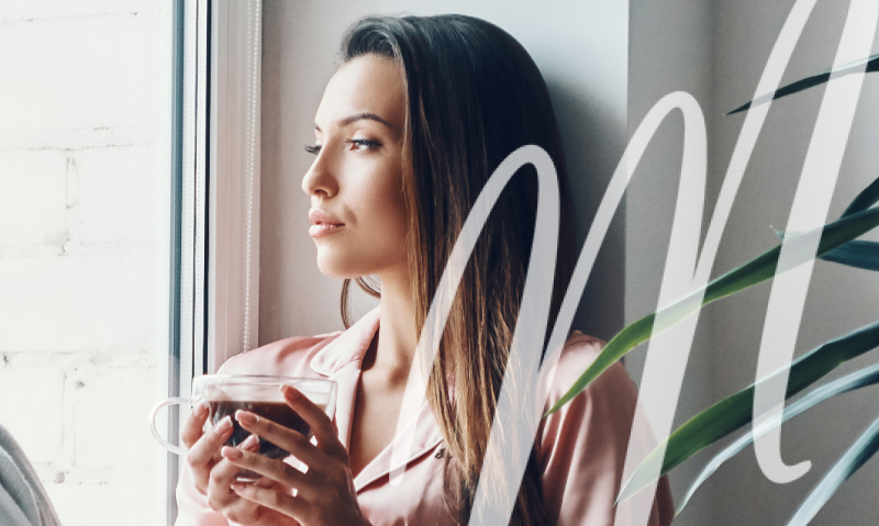 woman drinking coffee and looking out the window