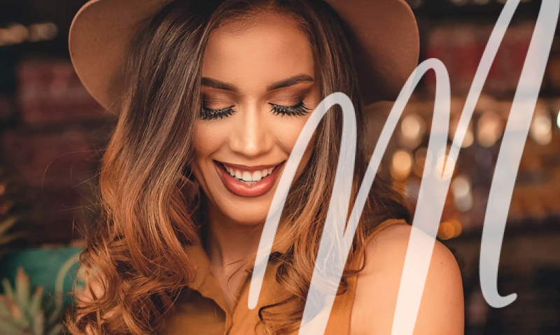 woman in brown hat and top smiling