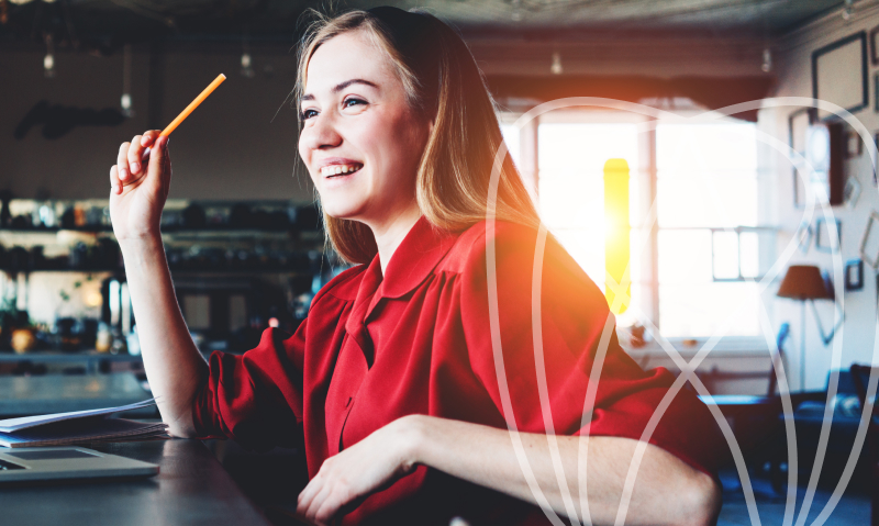 woman with a pencil smiling in a red shirt