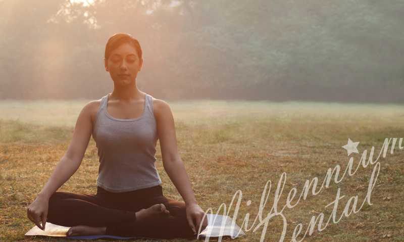 woman doing either yoga or meditation, or possibly both, in a semi-foggy field